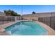 Large pool with blue water and fencing, complemented by minimal desert landscaping at 6332 Sierra Pines Ct, Las Vegas, NV 89130