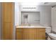 The bathroom has wood cabinets, a granite countertop, and a large mirror at 6955 N Durango Dr # 2099, Las Vegas, NV 89149