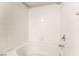 This bathtub has white tile walls and a shower head at 6955 N Durango Dr # 2099, Las Vegas, NV 89149