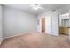 This carpeted bedroom features a ceiling fan, neutral walls, and access to a walk-in closet and bathroom at 6955 N Durango Dr # 2099, Las Vegas, NV 89149