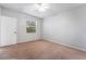 This carpeted bedroom features a window, neutral walls, and a white door at 6955 N Durango Dr # 2099, Las Vegas, NV 89149