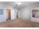 This carpeted bedroom features neutral walls, access to a bathroom and walk-in closet, and a ceiling fan at 6955 N Durango Dr # 2099, Las Vegas, NV 89149