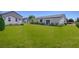 Sprawling backyard with lush lawn, landscaping, and access to the home through sliding glass doors at 790 Lone Pine Rd, Pahrump, NV 89048