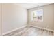 Neutral bedroom featuring wood-look floors and a window with backyard views at 790 Lone Pine Rd, Pahrump, NV 89048