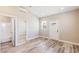 Open living room area featuring wood-look floors, neutral walls, and a door to a bath at 790 Lone Pine Rd, Pahrump, NV 89048