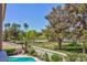 Landscaped backyard with a sparkling pool, mature trees, and green grass provides a private outdoor space at 8244 Horseshoe Bend Ln, Las Vegas, NV 89113