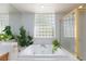 Bathtub with glass block window with natural light and a glass-enclosed shower offer a spa-like experience at 8244 Horseshoe Bend Ln, Las Vegas, NV 89113