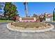 A beautifully landscaped entrance featuring the Carmel Circle sign and colorful flowers against a clear blue sky at 8244 Horseshoe Bend Ln, Las Vegas, NV 89113