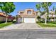 Charming two-story home features a terracotta roof, lush landscaping, and a spacious three-car garage at 8244 Horseshoe Bend Ln, Las Vegas, NV 89113