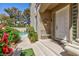 Charming front porch with elegant white door, bench, and lush landscaping leading to a beautiful pool at 8244 Horseshoe Bend Ln, Las Vegas, NV 89113