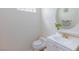 Well-lit powder room featuring a toilet, sink, vanity, and a decorative mirror at 8244 Horseshoe Bend Ln, Las Vegas, NV 89113