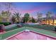 Lush backyard featuring a putting green, seating areas, and a serene pool with rock features at 8275 W Craig Rd, Las Vegas, NV 89129