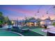 A beautiful backyard with a putting green, swimming pool, and outdoor lounging areas under string lights at 8275 W Craig Rd, Las Vegas, NV 89129