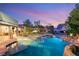 Serene backyard oasis featuring a sparkling pool with a rock waterfall and putting green at 8275 W Craig Rd, Las Vegas, NV 89129