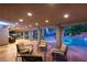 Relaxing covered patio with cozy seating overlooking a beautiful pool, putting green and lush landscaping at 8275 W Craig Rd, Las Vegas, NV 89129