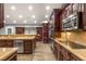 Gourmet kitchen featuring custom cabinets, stone counters, stainless steel appliances, and hardwood floors at 8275 W Craig Rd, Las Vegas, NV 89129
