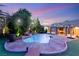 Stunning pool area with a rock waterfall, surrounded by lush greenery and a putting green at 8275 W Craig Rd, Las Vegas, NV 89129