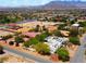 Aerial view of a modern white house, showing the surrounding neighborhood and a mountain range in the background at 8525 W Verde Way, Las Vegas, NV 89149