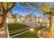 Backyard featuring a manicured artificial lawn, meditation statue, and sleek design, perfect for relaxation at 8525 W Verde Way, Las Vegas, NV 89149
