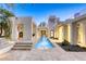 Modern home backyard with a water feature, travertine tile, desert landscaping, and sleek architectural details at 8525 W Verde Way, Las Vegas, NV 89149