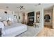 Spacious bedroom featuring hardwood floors, designer headboard, ceiling fan and fireplace with decor on both sides at 8525 W Verde Way, Las Vegas, NV 89149