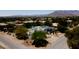 View of the exterior of the modern white house with lush landscaping and the background view of mountains at 8525 W Verde Way, Las Vegas, NV 89149