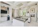 Bright kitchen with island, a wet bar, tiled floor and featuring modern appliances and stylish lighting at 8525 W Verde Way, Las Vegas, NV 89149