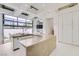 Modern kitchen featuring an island with seating, modern appliances and a wall of windows leading to an outdoor patio at 8525 W Verde Way, Las Vegas, NV 89149