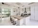 Bright kitchen featuring an island with seating, modern appliances, a stylish faucet and a view to the backyard at 8525 W Verde Way, Las Vegas, NV 89149