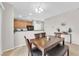 The dining area with wood table, bench, and chairs sits adjacent to the kitchen with neutral walls and carpet flooring at 9024 Hazy Haven Ct, Las Vegas, NV 89149