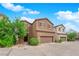 Charming two-story home with a two-car garage and desert landscaping under a bright blue, partly cloudy sky at 9024 Hazy Haven Ct, Las Vegas, NV 89149