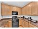 Updated kitchen features modern appliances and a granite countertop with wooden cabinets and a white backsplash at 9024 Hazy Haven Ct, Las Vegas, NV 89149