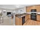 Open concept kitchen with wood flooring, stainless appliances, and a view of the living and dining areas at 9024 Hazy Haven Ct, Las Vegas, NV 89149
