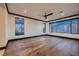 Bright bedroom with hardwood floors, a modern ceiling fan, and large windows offering natural light and views at 917 Vegas View Dr, Henderson, NV 89052