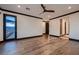Spacious bedroom with hardwood floors, black trim, ceiling fan, and glass door leading to the balcony with a view at 917 Vegas View Dr, Henderson, NV 89052
