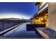 Modern home featuring a sleek, dark-tiled pool with an incredible view at dusk at 917 Vegas View Dr, Henderson, NV 89052