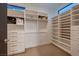 Well-organized walk-in closet featuring custom shelving, drawers, hanging rods, and carpet flooring at 917 Vegas View Dr, Henderson, NV 89052
