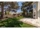 Backyard with concrete patio, lush lawn and mature trees at 9491 Gainey Ranch Ave, Las Vegas, NV 89147