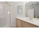 Bright bathroom features a tiled shower with gold trim and a modern vanity with a large mirror at 9491 Gainey Ranch Ave, Las Vegas, NV 89147