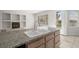 Granite island with double sink and views to backyard and fireplace with built-in shelving at 9491 Gainey Ranch Ave, Las Vegas, NV 89147