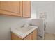 Bright laundry room offers a utility sink with modern appliances and functional cabinet space at 9491 Gainey Ranch Ave, Las Vegas, NV 89147