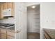 Walk-in pantry with shelving adjacent to the kitchen and stove at 9491 Gainey Ranch Ave, Las Vegas, NV 89147