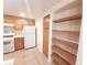 This kitchen offers wood cabinets, white appliances, and a pantry, set on neutral-toned tile floors at 9580 W Reno Ave # 183, Las Vegas, NV 89148