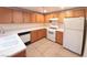 A functional kitchen includes wood cabinets, white countertops, and appliances on neutral tile floors at 9580 W Reno Ave # 183, Las Vegas, NV 89148