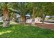 Well-manicured backyard with mature palm trees, grass lawn, and a gravel covered area at 1004 Yucca Ave, Las Vegas, NV 89104