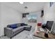 Upstairs bonus room featuring a gray sectional, a desk, and ample natural light at 103 Trout Creek Ct, Las Vegas, NV 89123