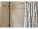 Close up of tan-tiled shower with decorative shower curtain and rainfall shower head at 10601 India Hawthorn Ave, Las Vegas, NV 89144