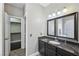 Bathroom featuring granite counters, a dark cabinet, and a door to a walk-in closet at 10601 India Hawthorn Ave, Las Vegas, NV 89144