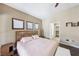 Bedroom featuring three windows, dark wood floors, and a decorative headboard at 10601 India Hawthorn Ave, Las Vegas, NV 89144