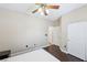 Bright bedroom featuring dark wood floors, ceiling fan and white closet doors at 10601 India Hawthorn Ave, Las Vegas, NV 89144
